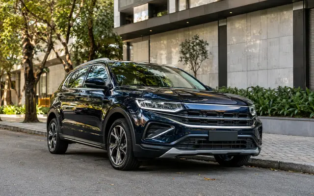 SUV escuro estacionado em frente a residência moderna
